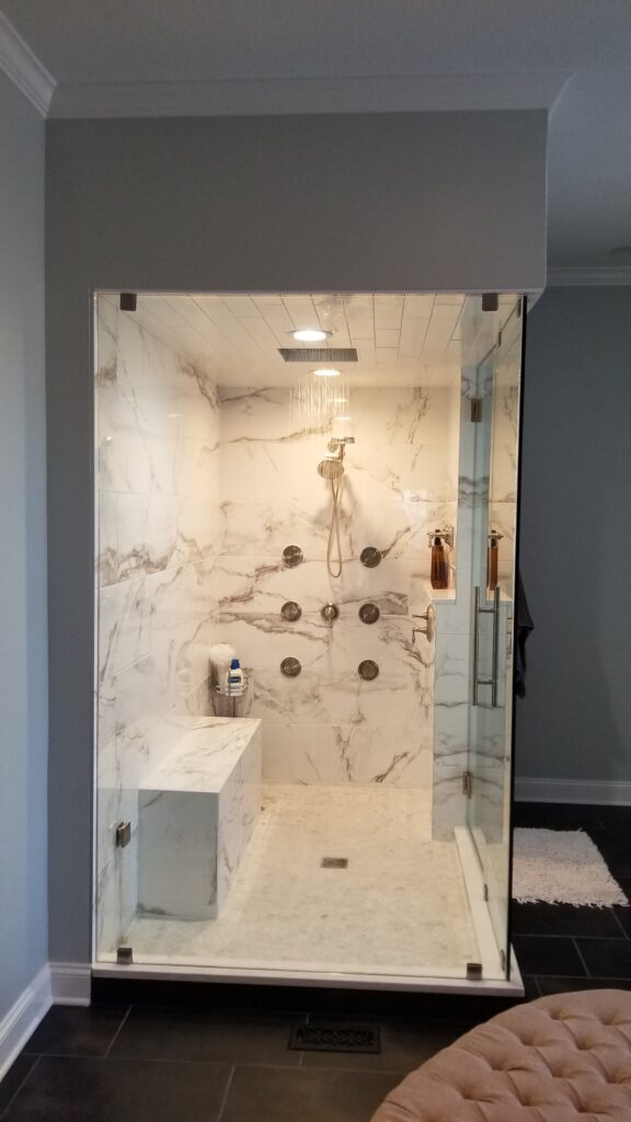 Premium master bathroom finish selections including custom fluted white oak floating vanity, sintered stone countertops, and brushed brass PVD fixtures.