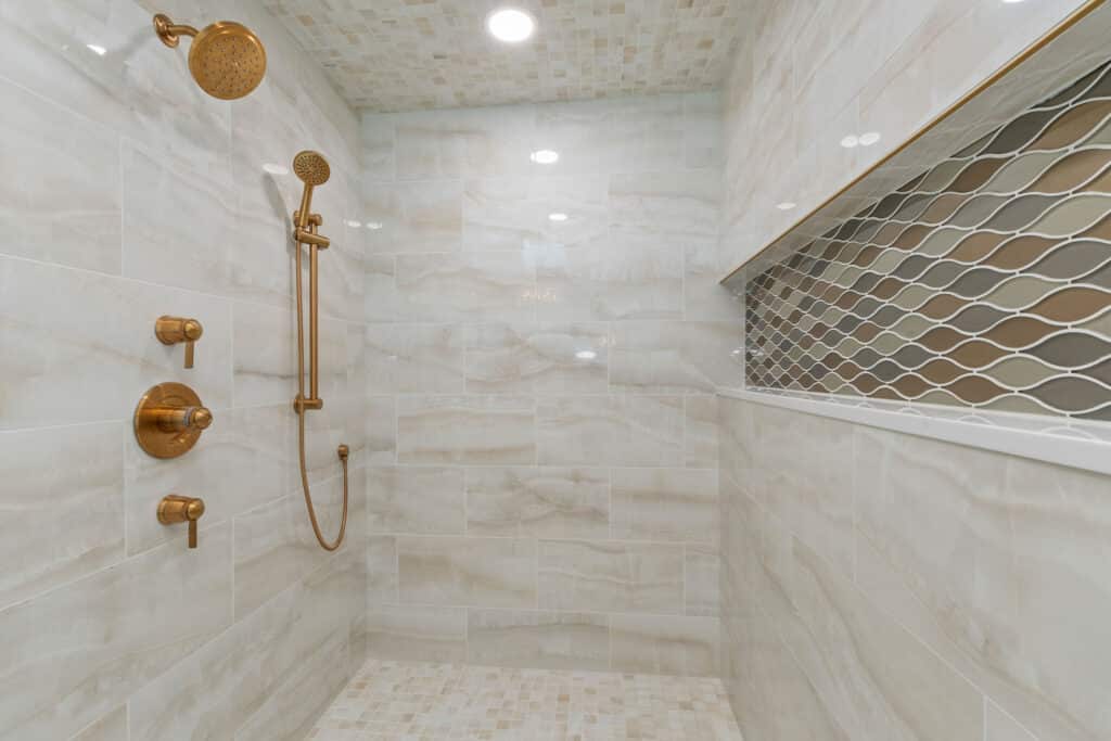 Custom 48-inch Grand Infiniti Niche lined with seamless quartz slab sitting over a freestanding soaking tub in a primary wet room.