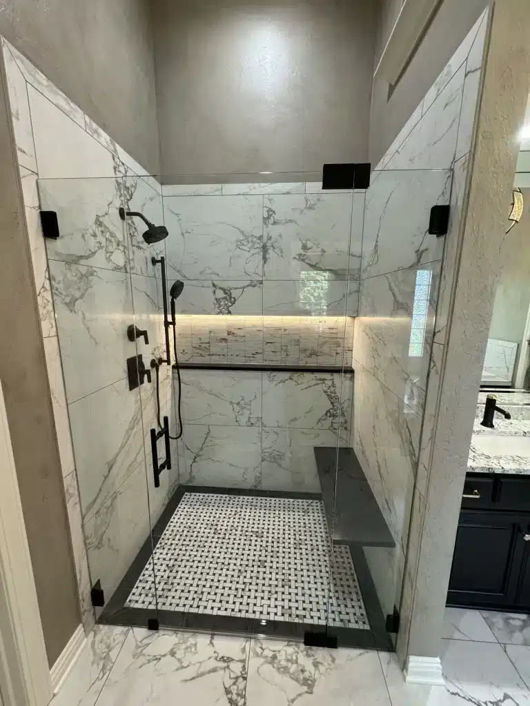 Modern luxury bathroom remodel in Kansas City featuring custom tile walk-in shower with frameless glass enclosure and premium quartz vanities.